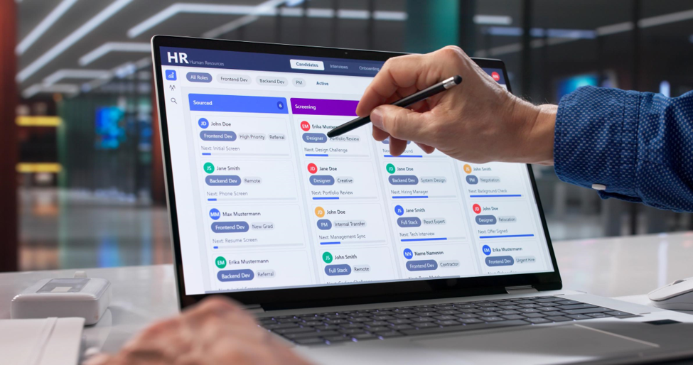 An HR recruiting kanban board on a laptop with candidate cards in Sourced and Screening columns; a hand points with a stylus.