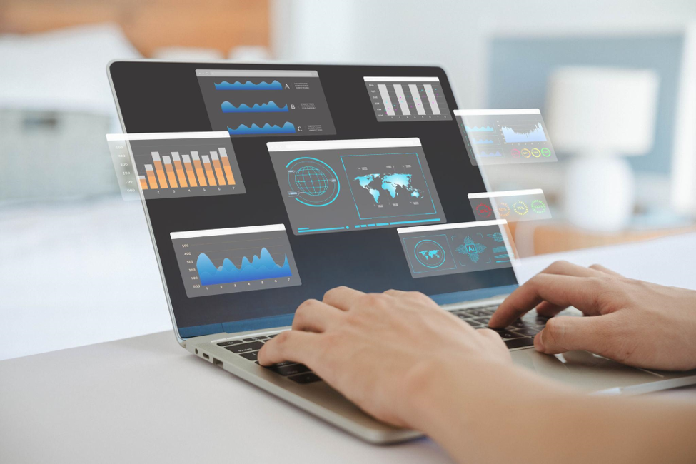 A laptop with floating holographic dashboards and charts, representing an AI research and data-analysis assistant.
