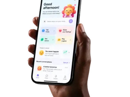 Phone in hand showing the companion app home screen with a cheerful mascot, quick actions, today's mood and recent conversations