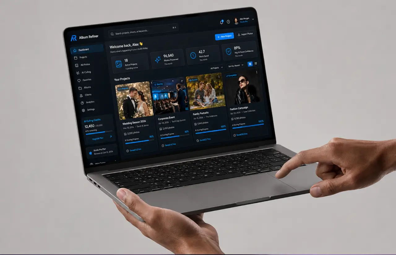 Hands holding a laptop showing the Album Refiner dashboard: 18 active projects, 96,540 photos processed, 42.7 hours saved and 89% average AI score confidence this month, above project cards for a wedding season, a corporate event, family portraits and a fashion campaign with their scoring progress