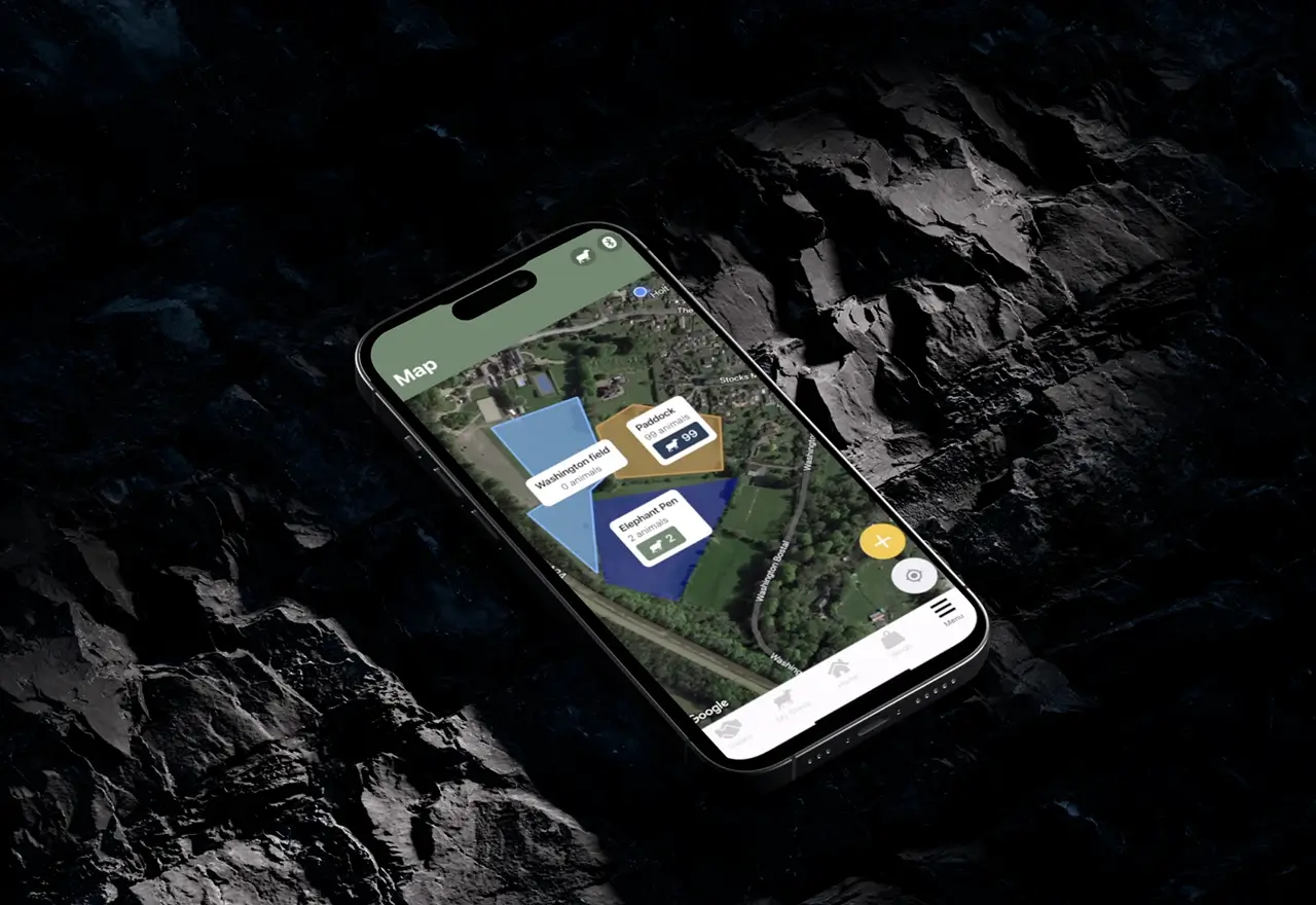 Phone showing a satellite map of the farm with coloured paddocks and the number of animals in each