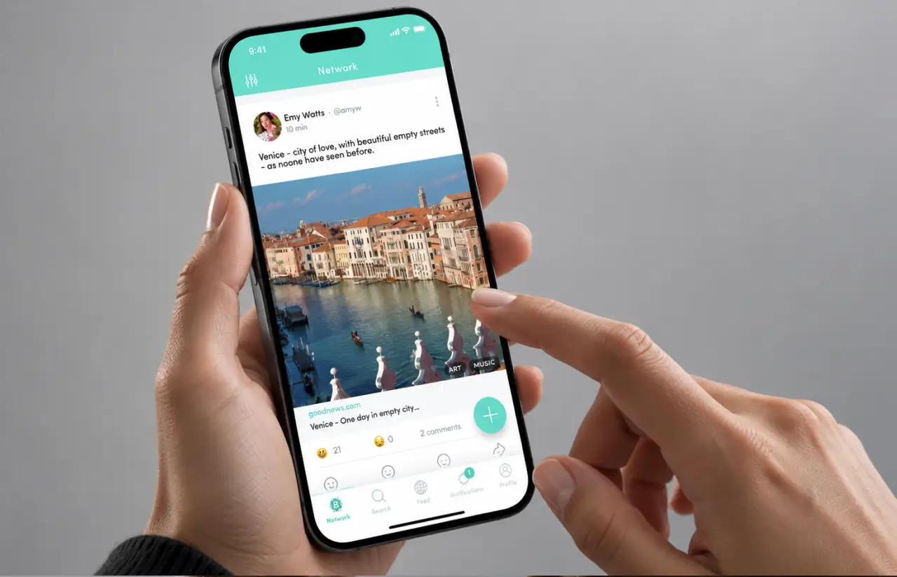 Phone in hand showing the network feed with a link post, category chips and a floating plus button
